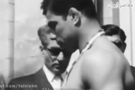 لحظه بسته شدن بازوبند پهلوانی بر بازوی غلامرضا تختی توسط محمدرضا پهلوی